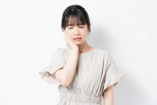 顎をおさえる女性